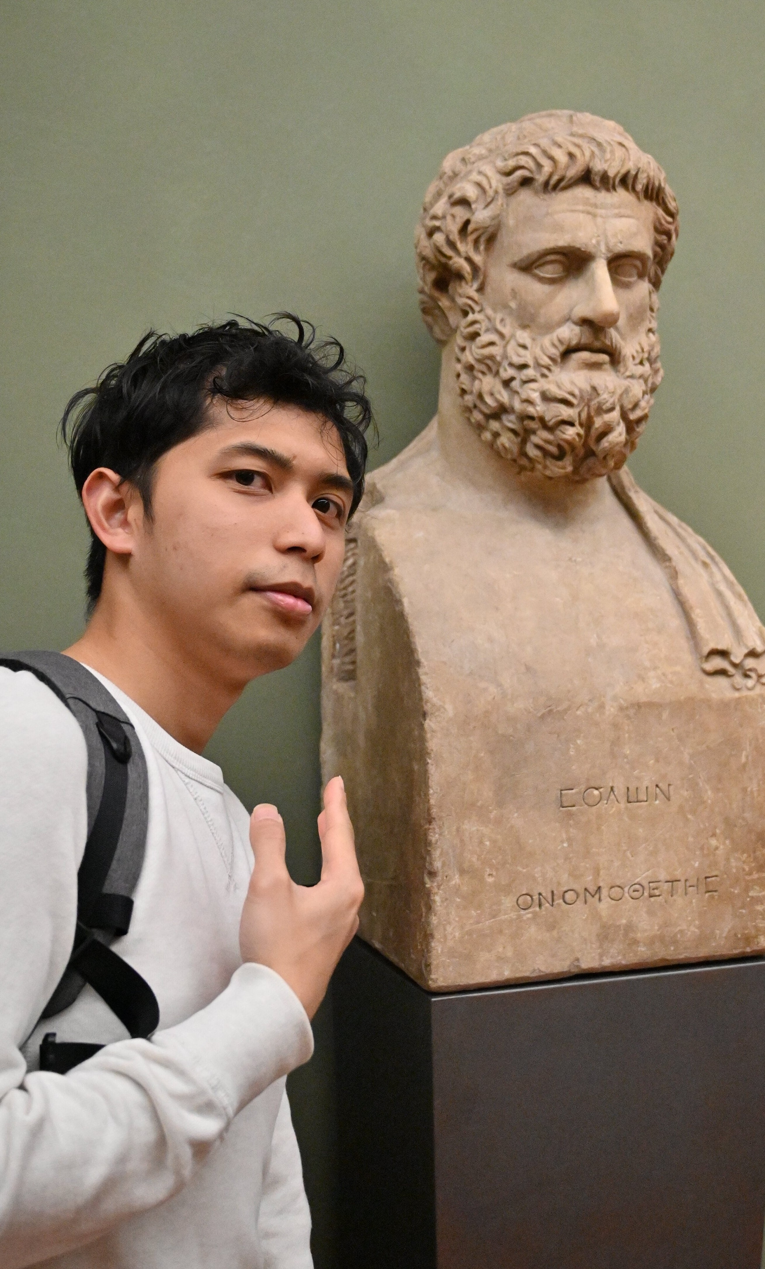 a man with white shirt posing in front of a mennequin